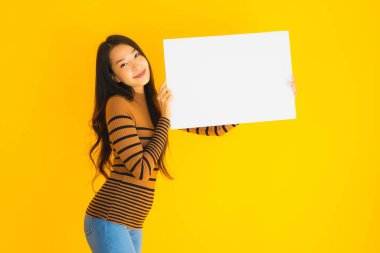 Sarı izole edilmiş arka plan üzerine yazılmış yazı için boş beyaz kartı olan güzel Asyalı kadın portresi.