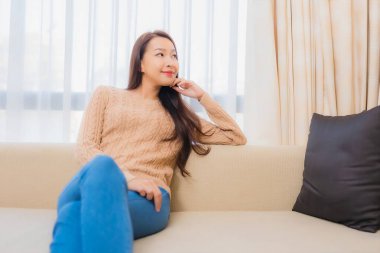 Güzel bir Asyalı kadın portresi rahatla. Gülümse. Yatak odasının iç dekorasyonunda mutlu ol.