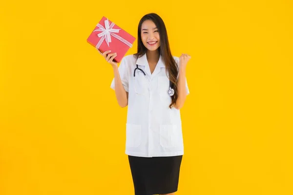 Портрет Красива Молода Азіатська Лікарка Показує Червону Подарункову Коробку Жовтому — стокове фото