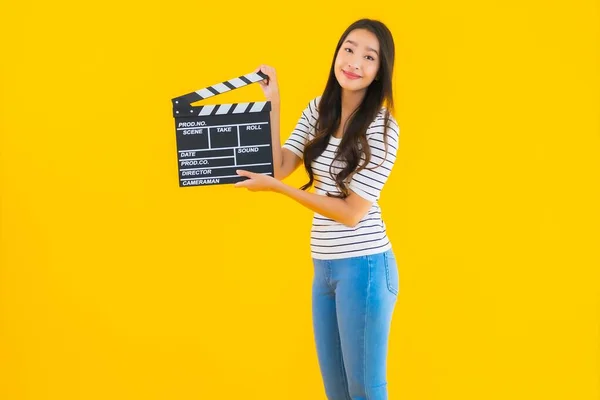 肖像美しい若いアジアの女性ショークラッパームービーボード上の黄色隔離された背景 — ストック写真