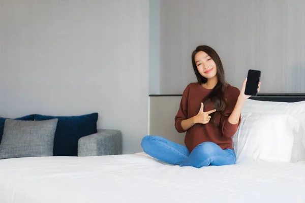 Güzel Bir Asyalı Kadın Yatak Odasının Içinde Akıllı Cep Telefonu — Stok fotoğraf
