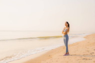 Portre sporu genç Asyalı kadın egzersiz hazırlıyor ya da sağlık için okyanusta koşuyor.