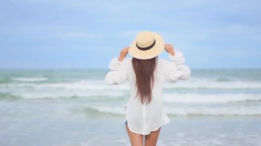 Yaz tatilinde deniz kıyısındaki Asyalı kadının görüntüleri.