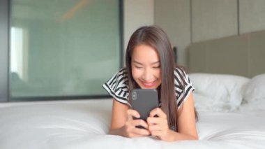 Güzel Asyalı kadının evde akıllı telefon kullandığının görüntüleri.