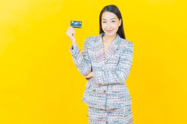 Güzel bir Asyalı kadının portresi. Renkli kredi kartıyla gülüyor.