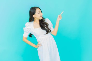 Portre güzel Asyalı kadın gülümsüyor. Renkli arka planda hareket var.