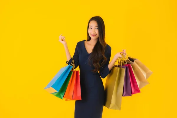 Sarı Izole Edilmiş Arka Planda Renkli Alışveriş Çantalı Güzel Asyalı — Stok fotoğraf