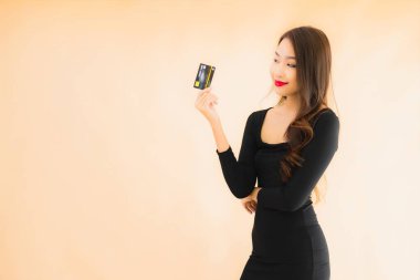 Renkli arka planda alışveriş yapmak için kredi kartı olan güzel bir Asyalı kadın portresi.