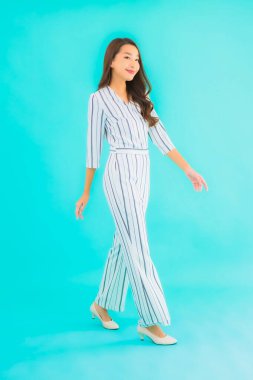 Asyalı güzel bir kadının portresi mavi izole edilmiş arka planda gülümsüyor.