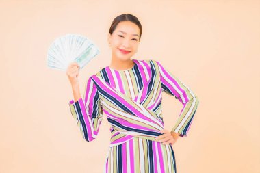 Parası, parası ve cep telefonu olan güzel Asyalı bir kadının portresi.