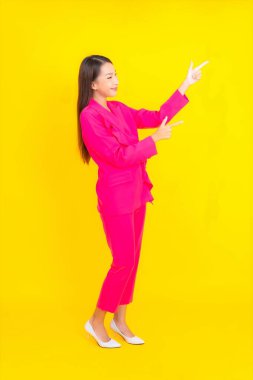 Güzel bir Asyalı kadın sarı arka planda gülümsüyor.