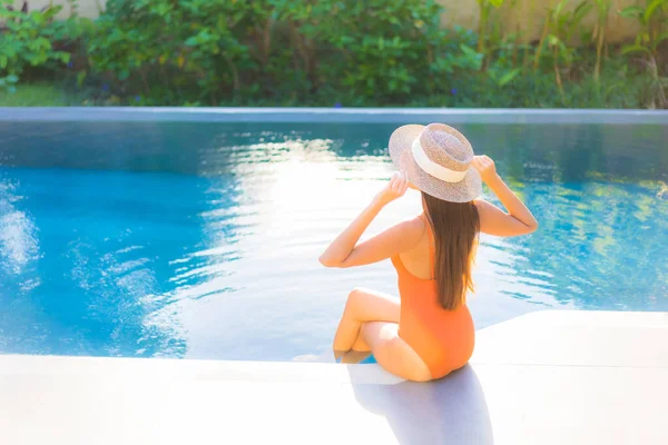 Güzel bir Asyalı kadının portresi tatil için yüzme havuzunda rahatlıyor.