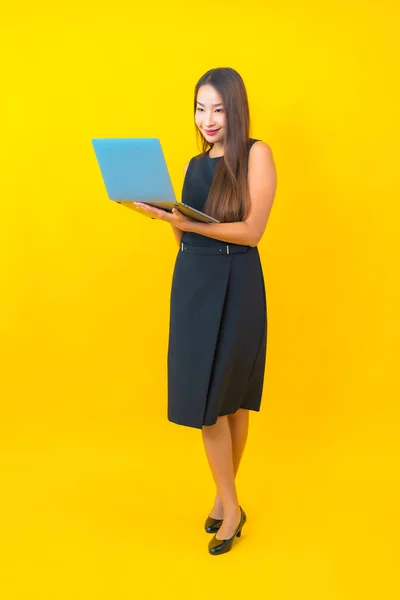Sarı Arka Planda Dizüstü Bilgisayarı Olan Güzel Asyalı Kadını Portresi — Stok fotoğraf