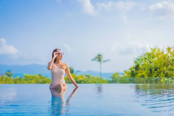 ポートレートの美しい若いアジアの女性は旅行休暇旅行で海の景色と屋外スイミングプールの周りを楽しむ — ストック写真