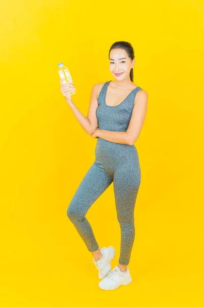 Portret Pięknej Młodej Azjatki Odzieżą Sportową Butelką Wody Żółtym Tle — Zdjęcie stockowe