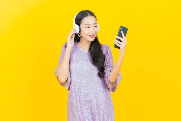 Portré Gyönyörű Fiatal Ázsiai Fejhallgató Okos Telefon Hallgatni Zenét Sárga — Stock Fotó