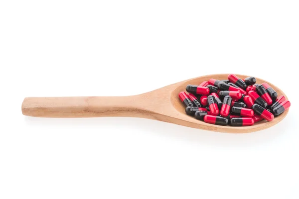 Pastillas de drogas en cuchara de madera aislada sobre fondo blanco — Foto de Stock