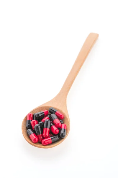Comprimidos droga na colher de madeira — Fotografia de Stock