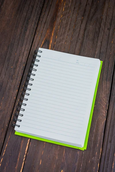 Livro de notas sobre fundo de madeira — Fotografia de Stock