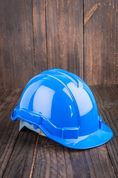 Construction hard hat on wooden background — Stock Photo, Image