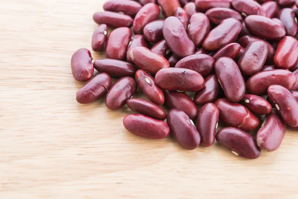 Červené fazole na dřevěné pozadí — Stock fotografie