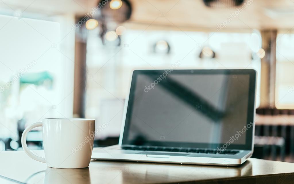 Coffee cup, laptop in coffee shop