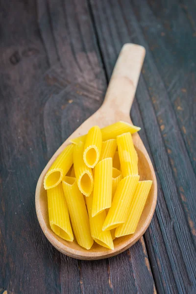 Raw pasta on spoon — Stock Photo, Image