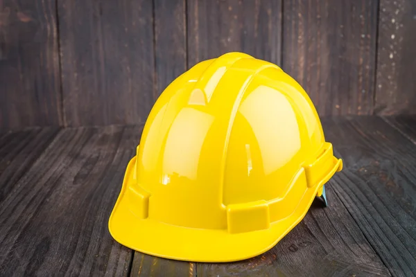 Construction hard hat on wooden background