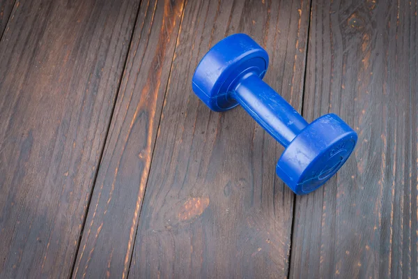 Dumbbell on wood background — Zdjęcie stockowe