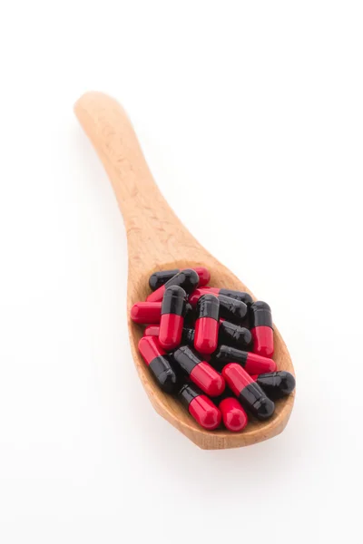 Tablet pill on wood spoon — Stock Photo, Image