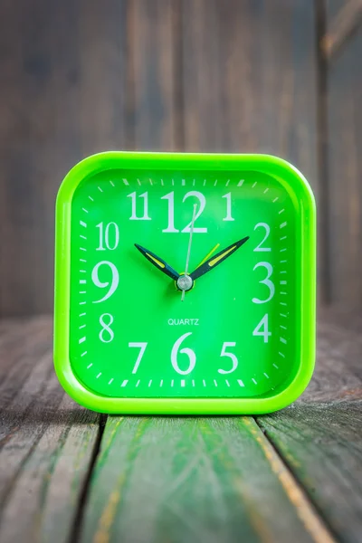 Reloj sobre fondo de madera — Foto de Stock