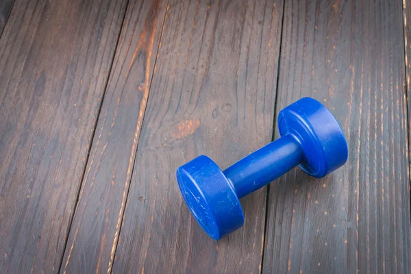 Dumbbell on wood background — Stockfoto