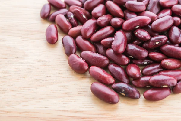 Červené fazole na dřevěné pozadí — Stock fotografie