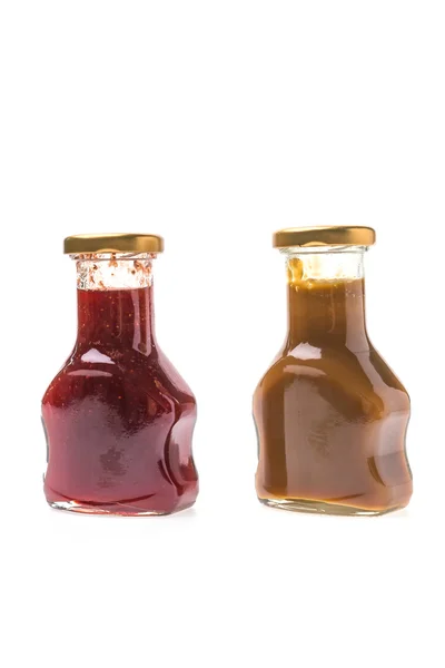 Molho de caramelo e garrafas de geléia de morango — Fotografia de Stock