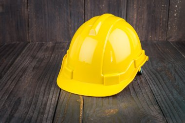 Ahşap arka plan üzerinde inşaat zor şapka