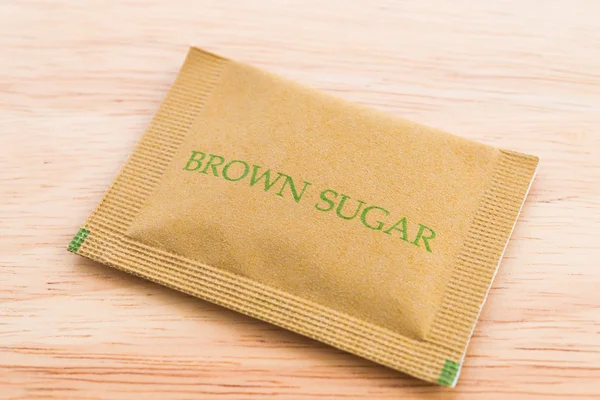 Bolsa de azúcar marrón sobre fondo de madera — Foto de Stock