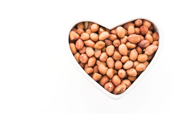 Jordnötter i hjärtat skål — Stockfoto