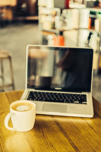 Koffiebeker en laptop — Stockfoto