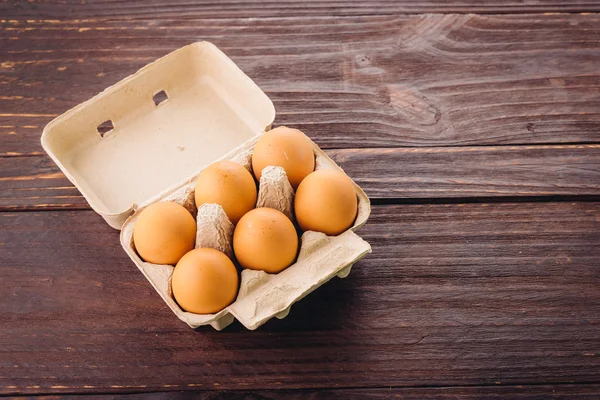 Eieren pack op hout achtergrond — Stockfoto