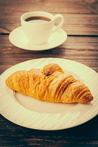 Croissant em prato e café — Fotografia de Stock
