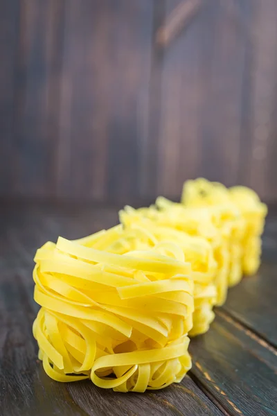 Raw pasta on wooden background — Stock Photo, Image