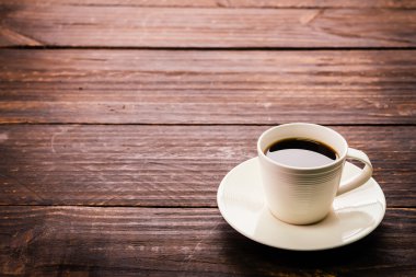 Kahve fincanı ahşap masada.