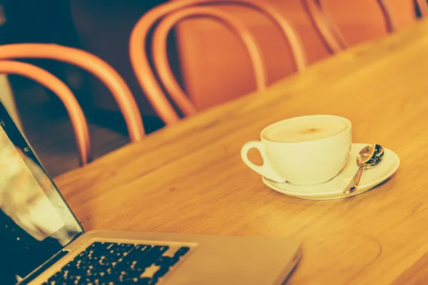 Tazza di caffè con computer portatile in caffetteria — Foto Stock