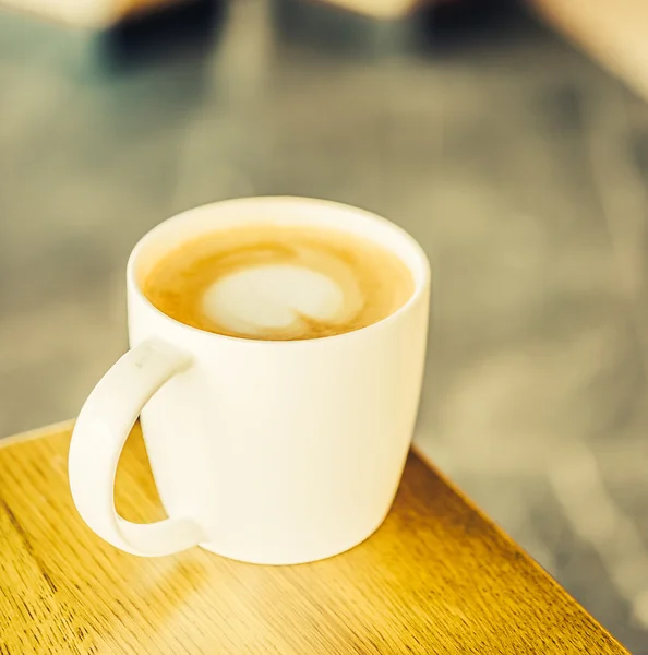 Filiżanka kawy na drewnianym stole — Zdjęcie stockowe