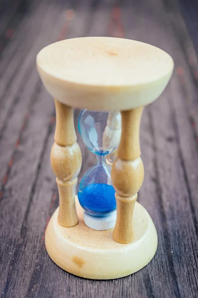 Vidrio de hora sobre fondo de madera — Foto de Stock