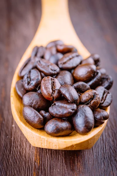 Grãos de café em colher de madeira — Fotografia de Stock