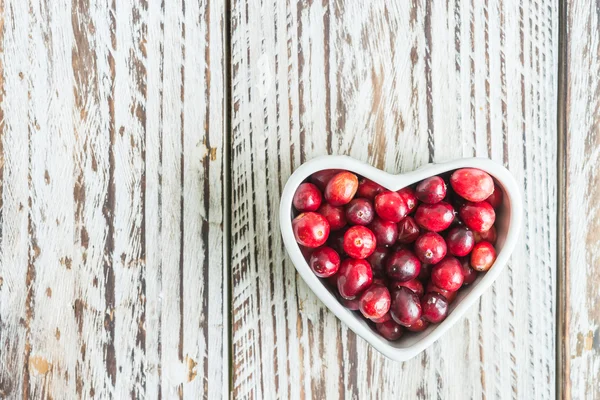 Cranberries in heart shaped bowl — Stock Photo, Image