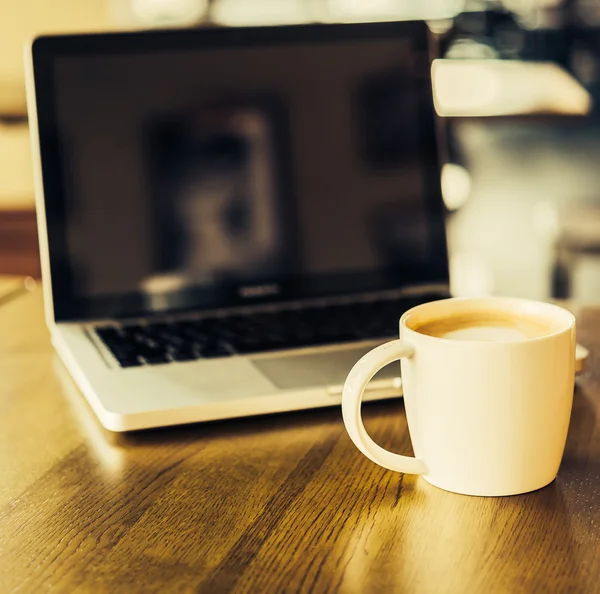 Koffiebeker en laptop — Stockfoto