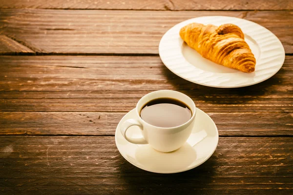 Croissant und Kaffee auf dem Tisch — Stockfoto