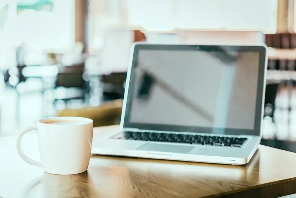 Koffiebeker en laptop — Stockfoto